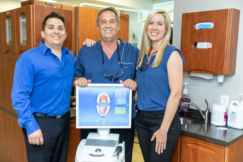 Three dentists at Eastman Dental Group in Lakewood Ranch, FL standing beside digital imaging equipment used for All-on-4 dental implant planning