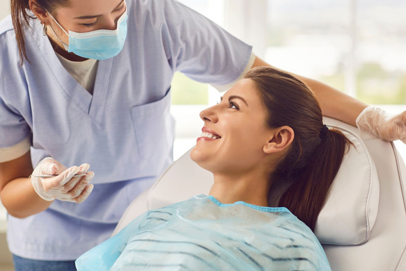 Smiling dental patient receiving friendly care from a professional dentist. Reflects comfort, trust, and a positive dental experience in a modern clinic setting.
